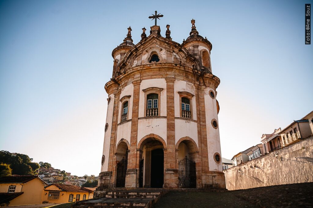 Fachada da Igreja de Nossa Senhora do Rosário dos Homens Pretos em Ouro Preto, Minas Gerais, destacando sua arquitetura barroca com linhas curvas e fachada em pedra.