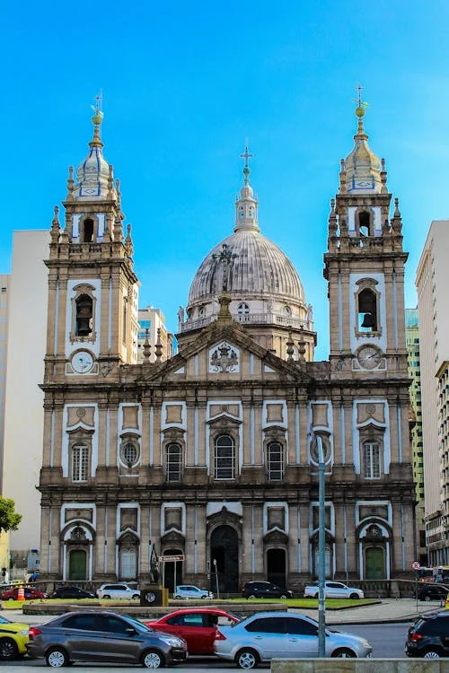Edifício de igreja histórica sob céu azul claro, simbolizando a presença contínua do sagrado na cidade.