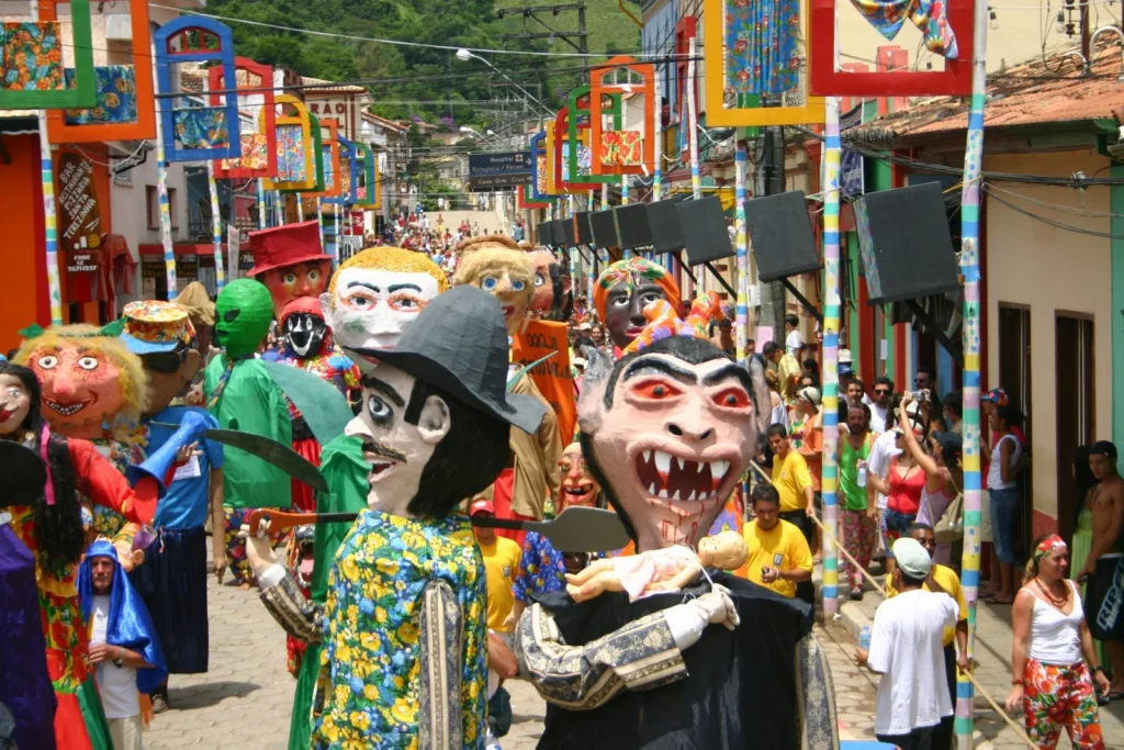 Desfile de bonecos gigantes e foliões durante as festividades em São Luiz do Paraitinga, São Paulo.